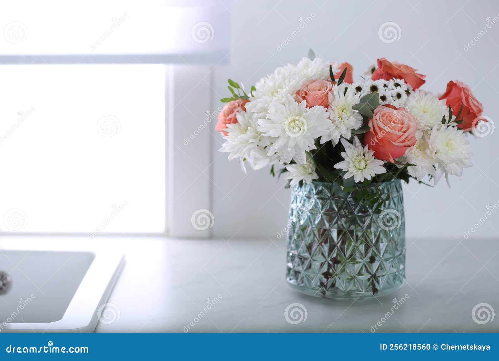 Vase with Beautiful Flowers on Countertop in Kitchen, Space for Text