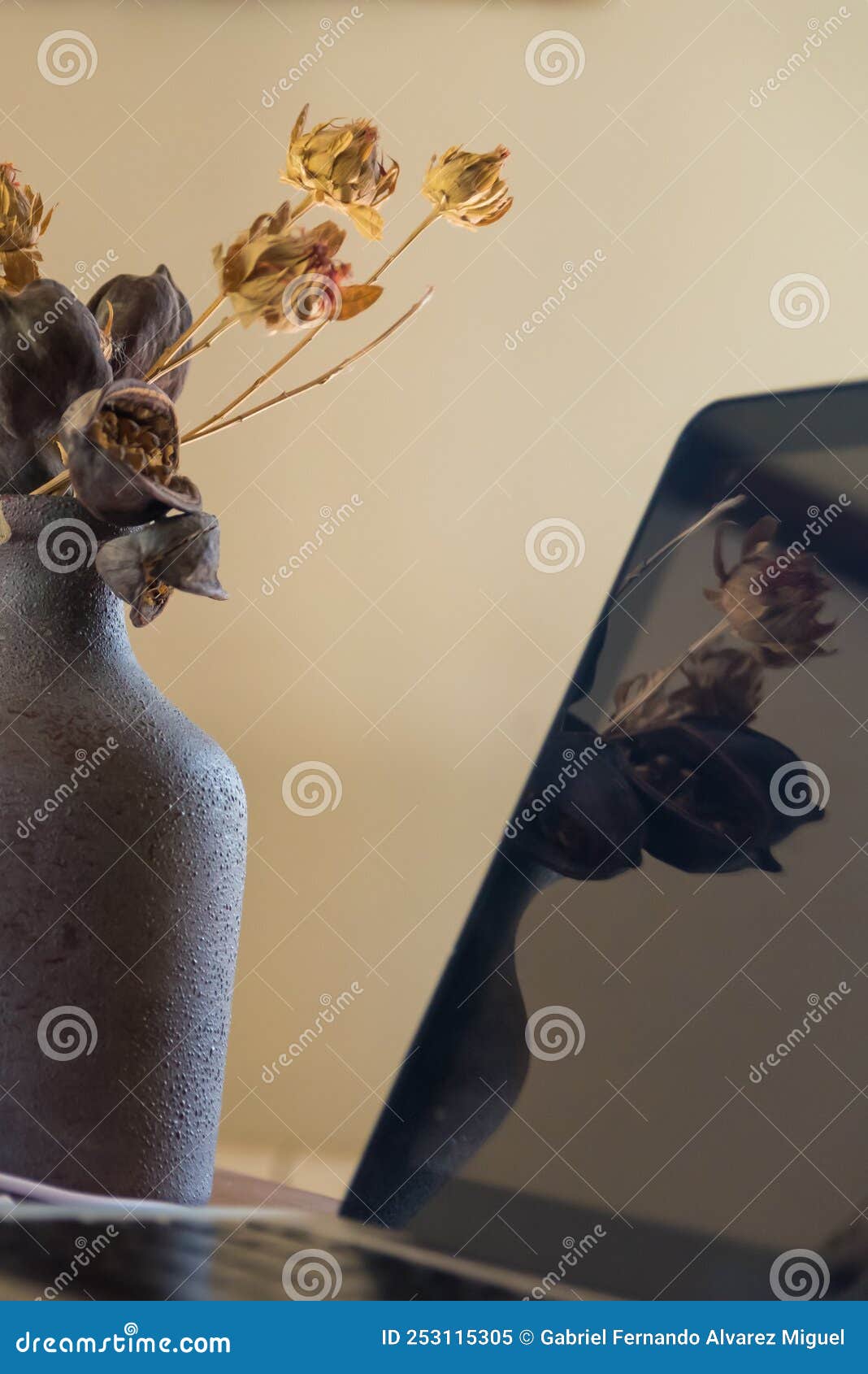 vase with dried flowers in front of a mirror