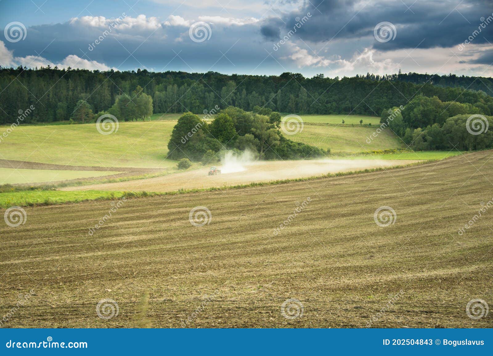 vast fields with a view of a working tractor.
