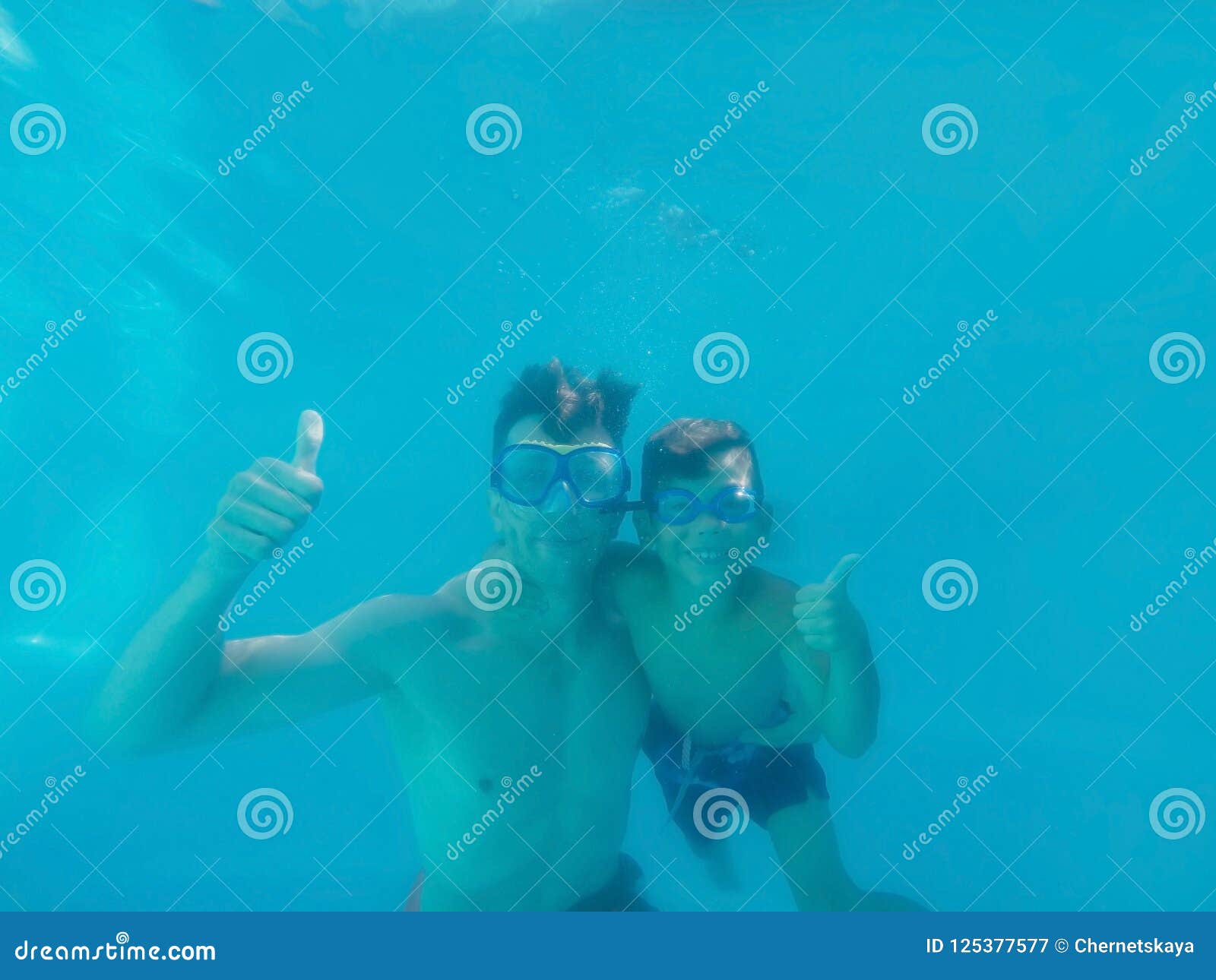Vater und Sohn Unterwasser im Swimmingpool
