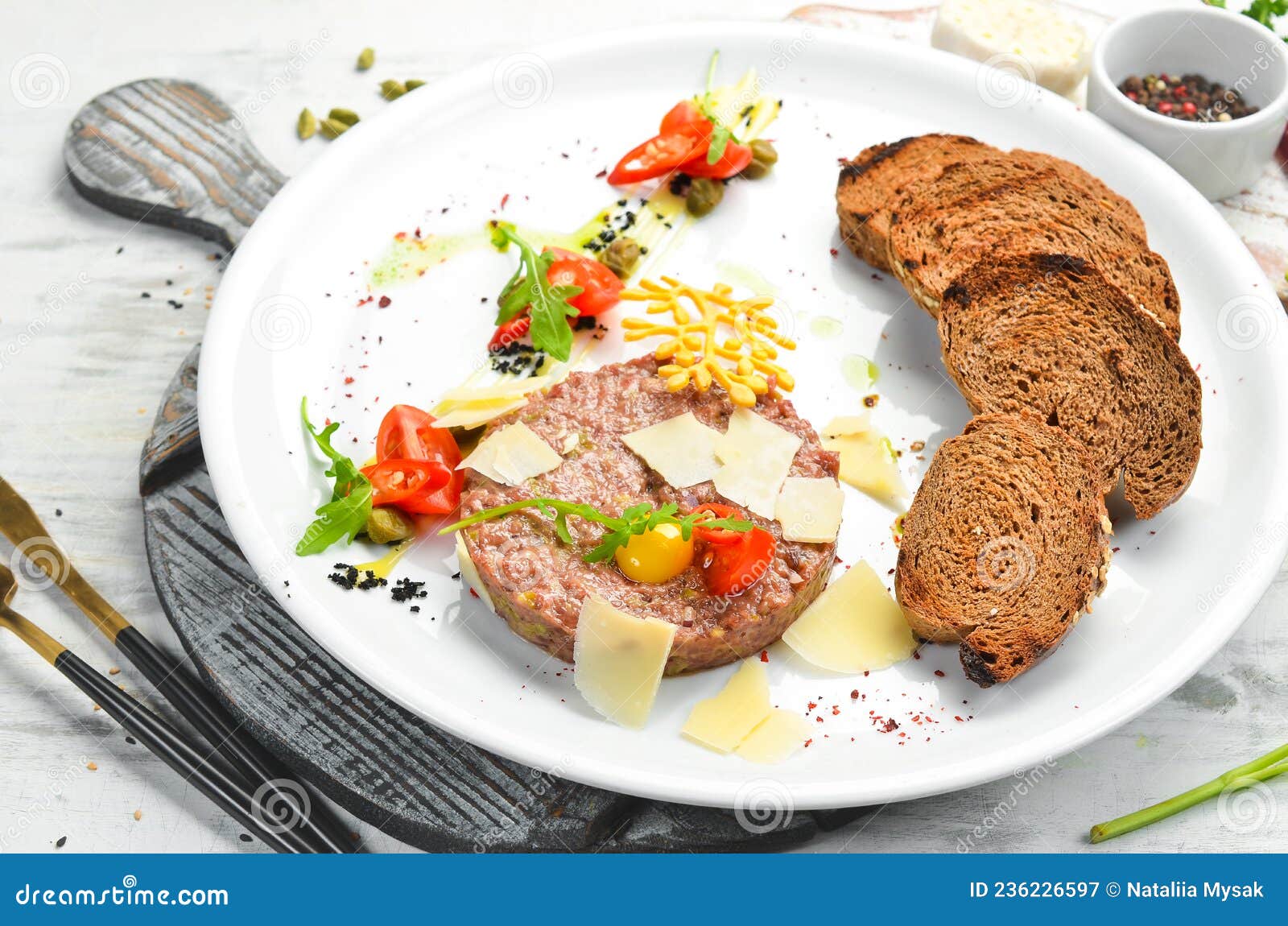 Veal Tartar, with Toast Bread and Vegetables on a White Plate. Stock
