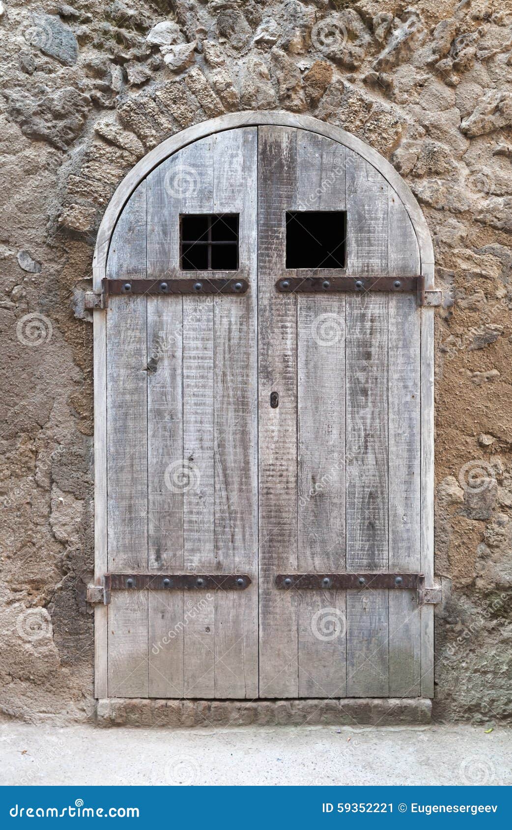 Vecchia porta di legno con l'arco in vecchia parete di pietra ...