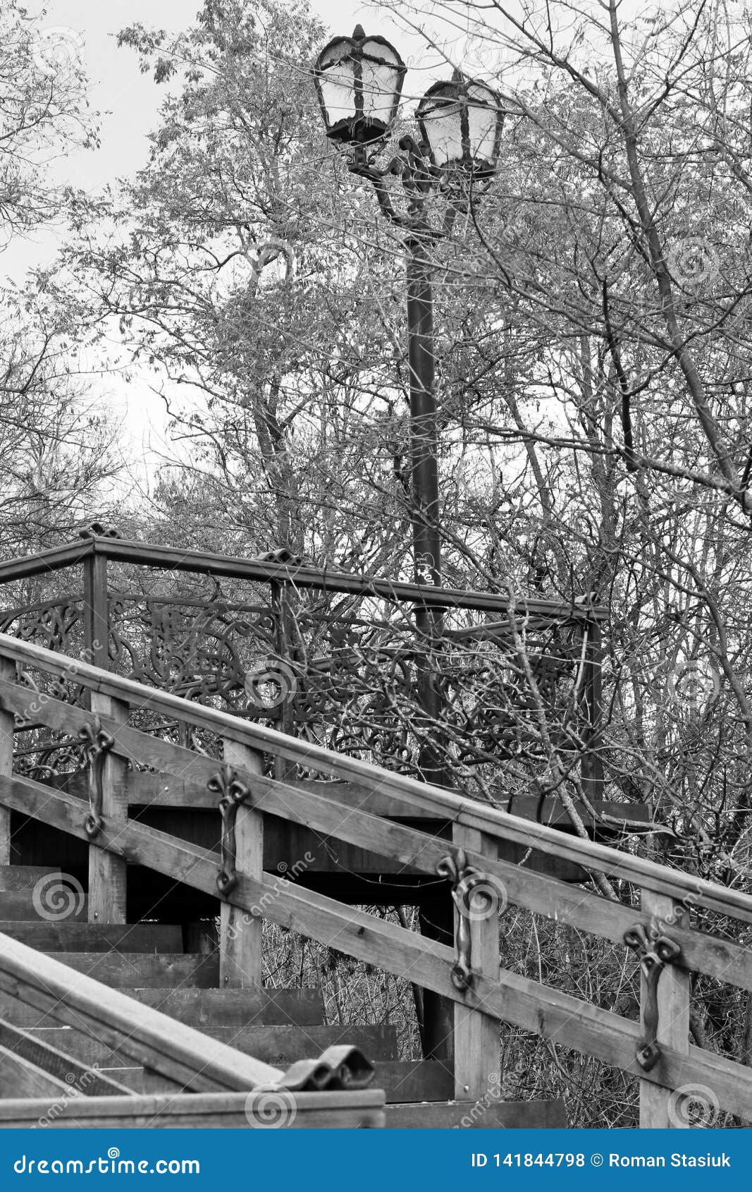 Vecchia scala Vecchia scala di legno con gli elementi del ferro battuto Vecchia scala nel parco Citt? Cernigov storia. Vecchia scala di legno nel parco Lanterne del ferro battuto