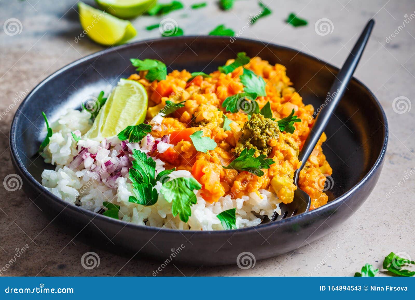 vegetarian lentil curry with rice in black plate. healthy vegan food concept