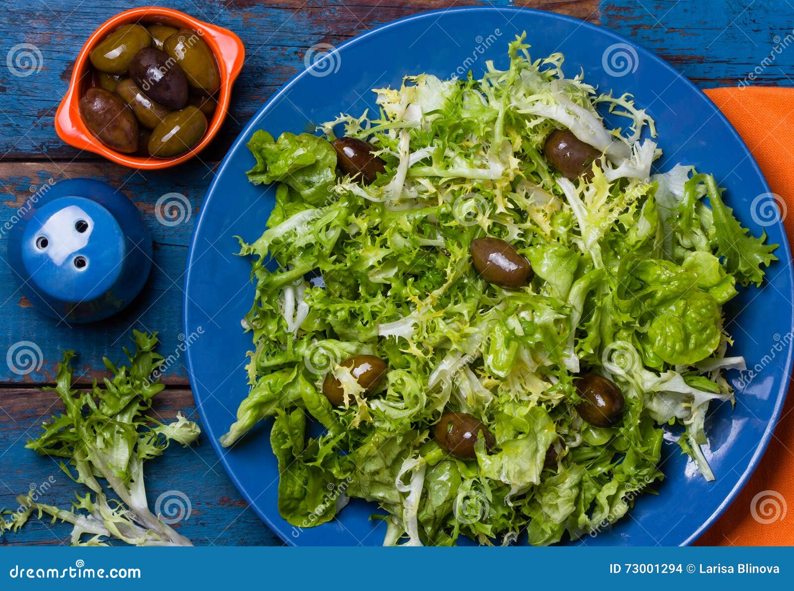 vegetarian salad with lettuce and olives. colorful blue orange background