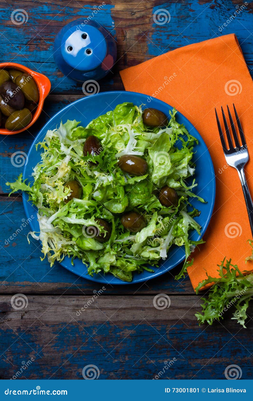 vegetarian salad with lettuce and olives. colorful blue orange background