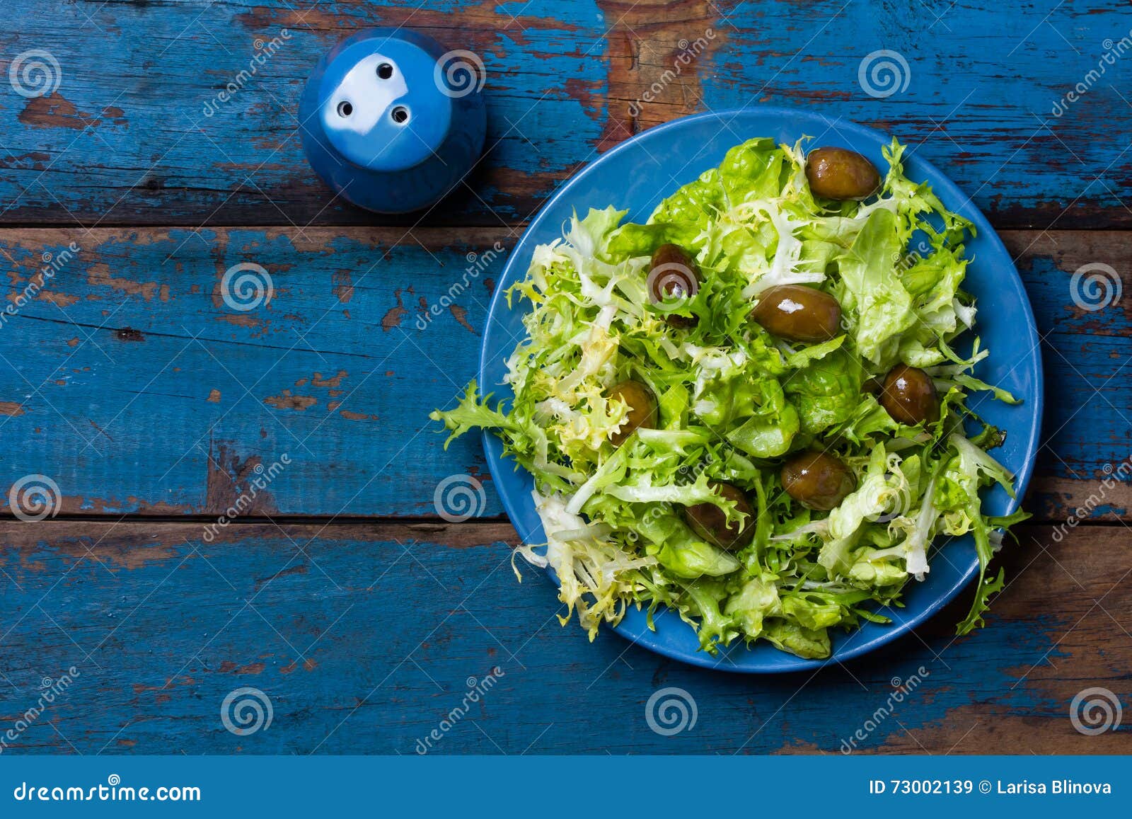 vegetarian salad with lettuce and olives. colorful blue orange background