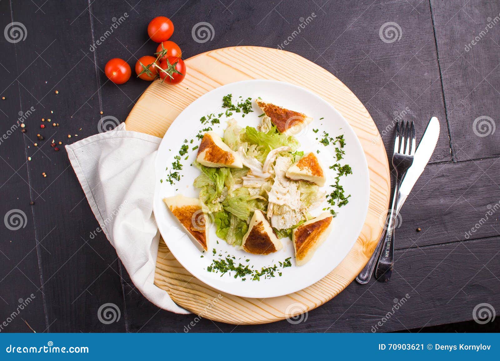 Vegeteriansalade met gebraden kaas. Concept: gezond voedsel De eigengemaakte Vegeterian-salade met gebraden kaas op witte plaat met ingrediënten paneert rond en bestek