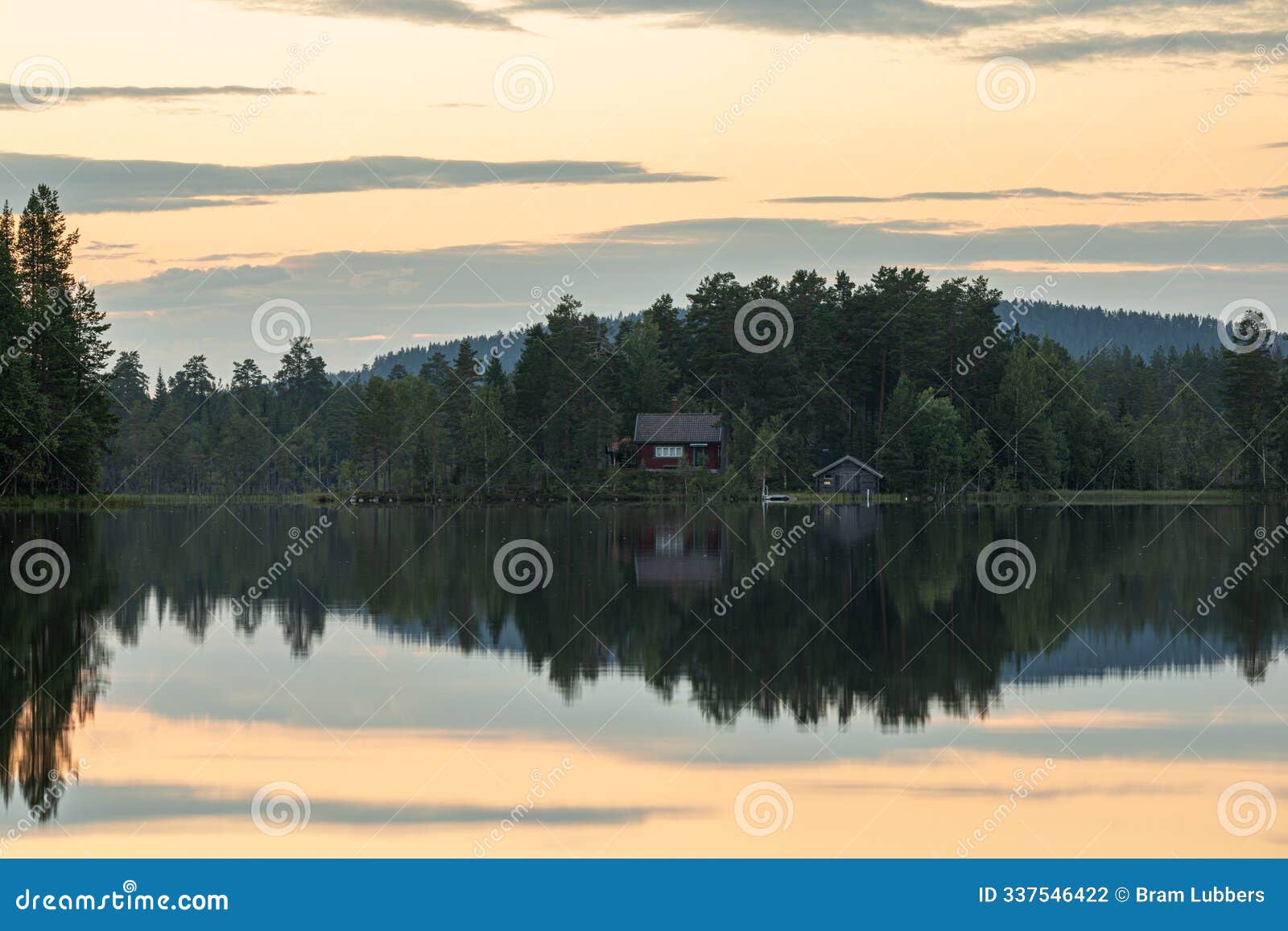 a typical swedish stuga among the trees by the lake. sweden is the land of lakes, trees, and the typical swedish red cottages, als