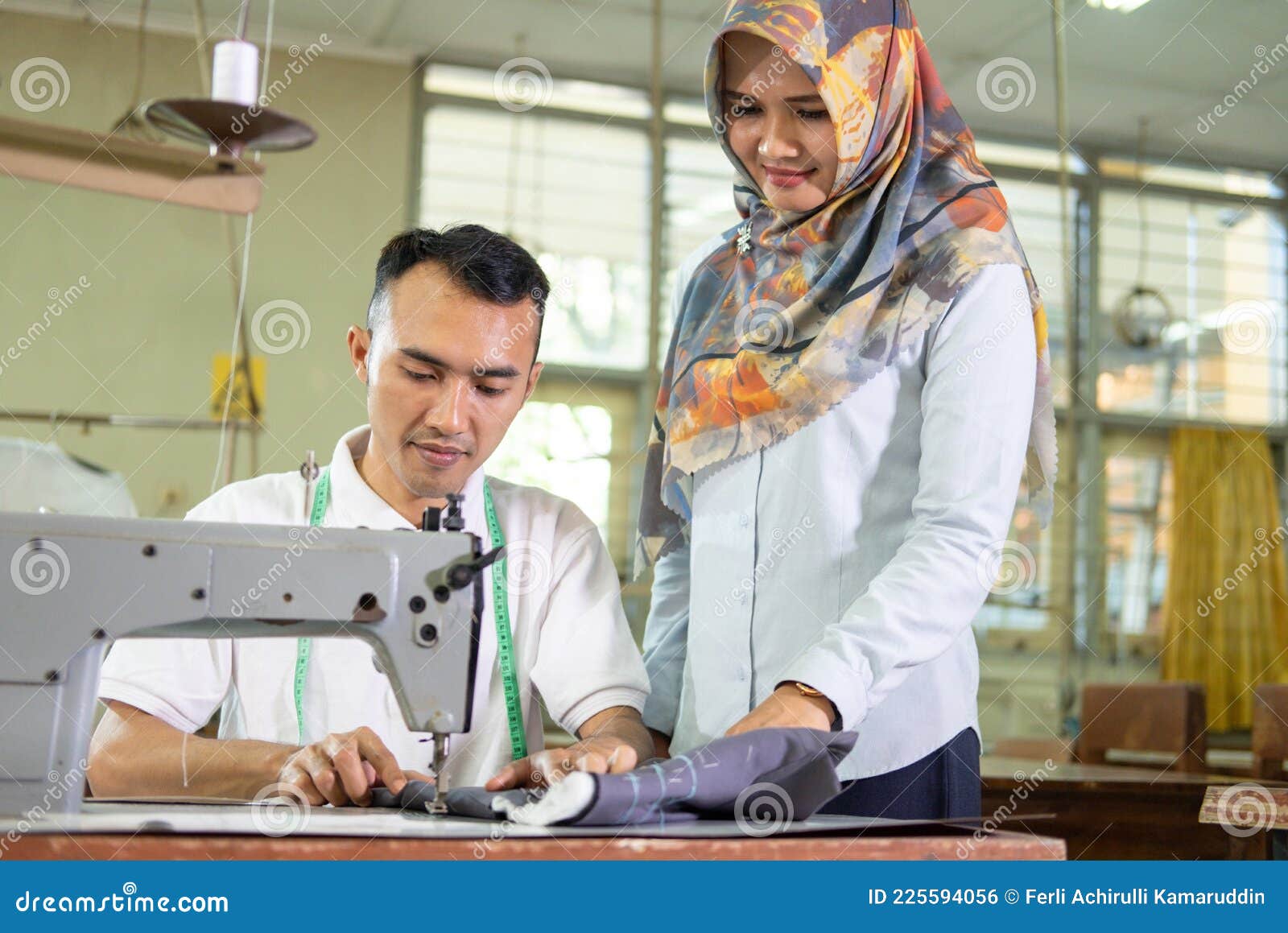 Veiled Supervisor Stands To Watch Over Employees Working on Sewing ...