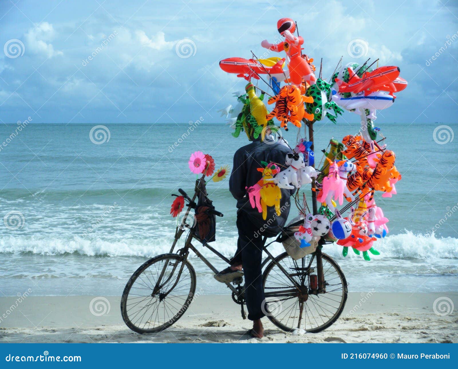 venditore di giocattoli in spiaggia con bicicletta