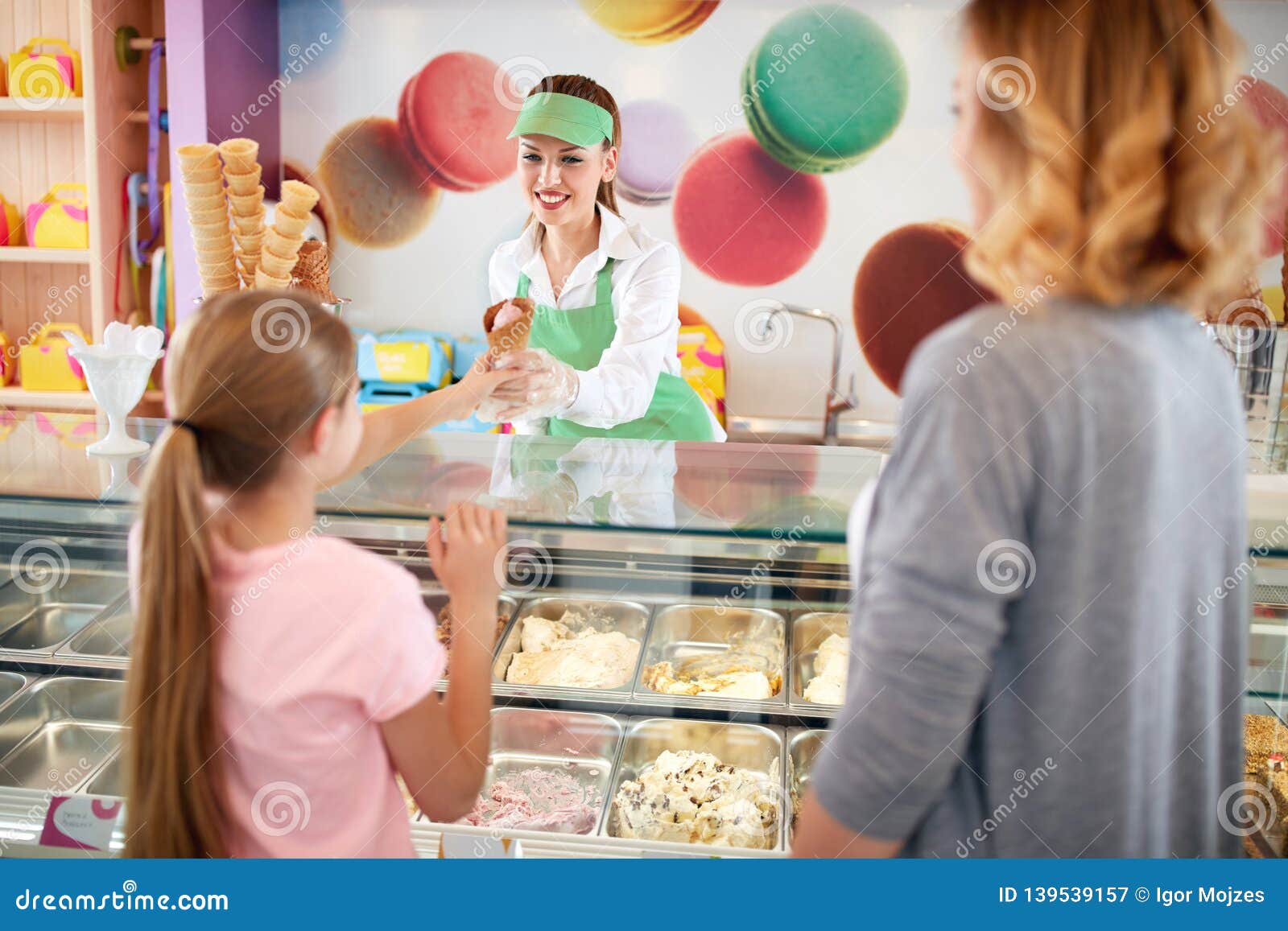 vendor in confectionery serves young customer