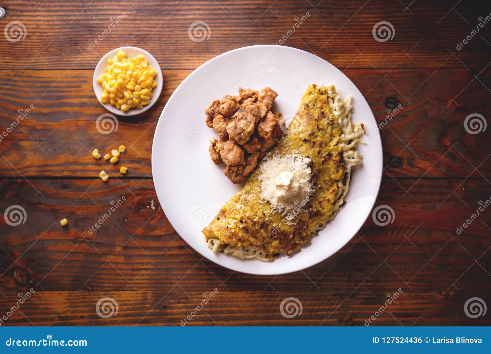 venezuelan food. corn cachapa with cheese and fried pork - cochino frito. wooden background, top view