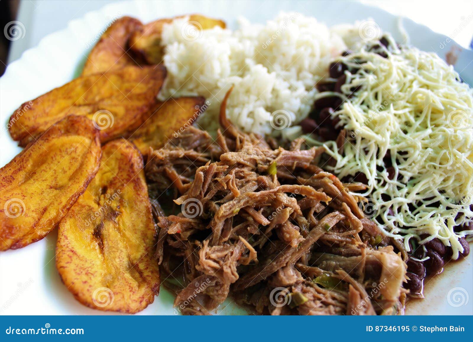 venezuelan typical dish called pabellon, made up of shredded meat, black beans, rice, fried plantain slices, and salty cheese.