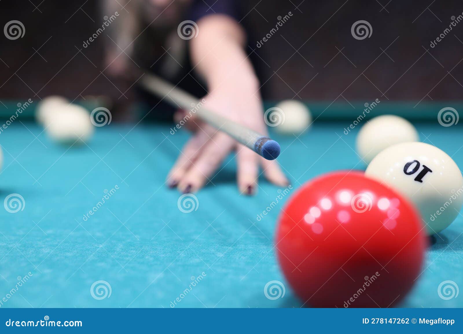 venturous woman ready to hit red ball on blue pool table