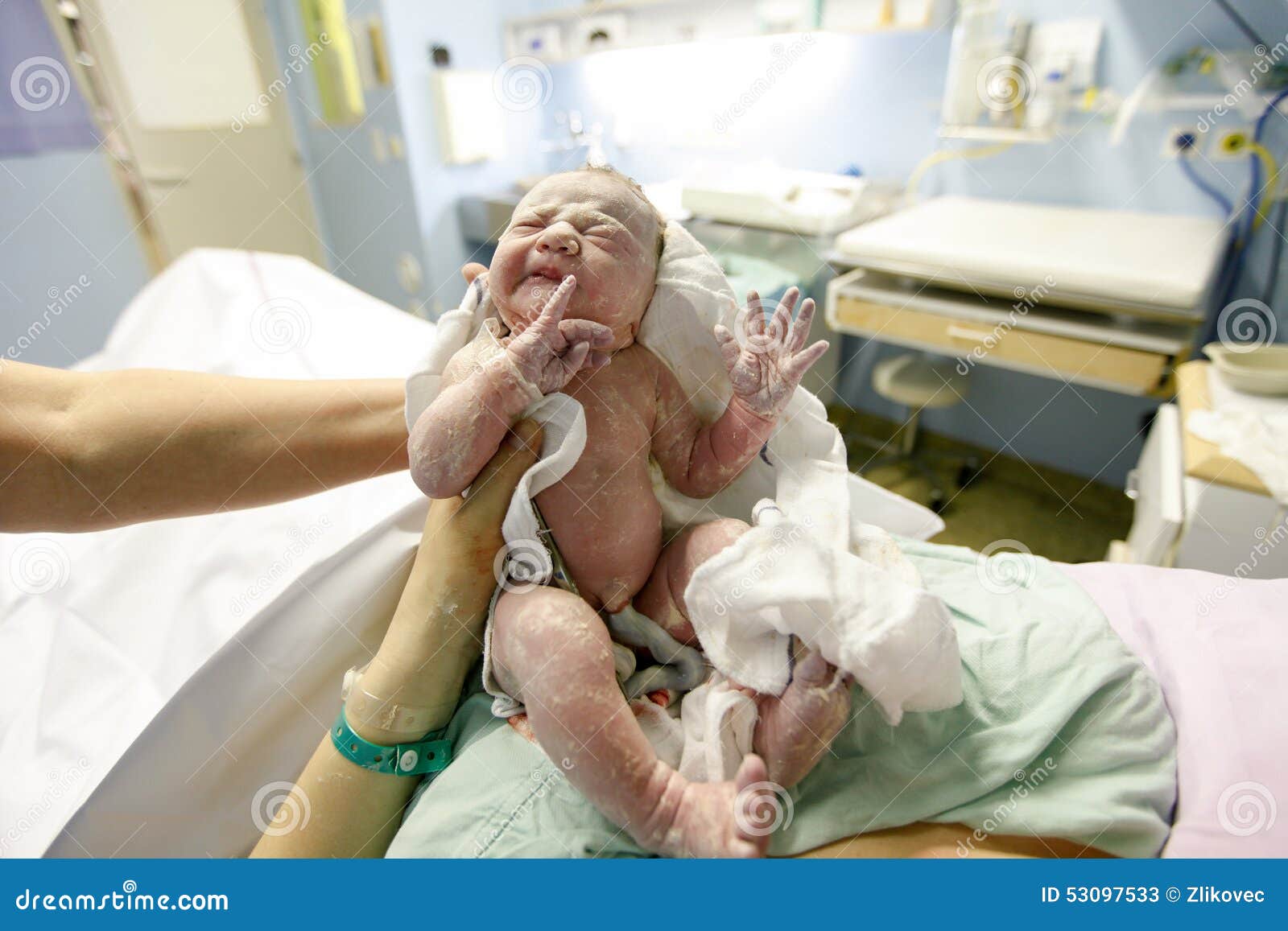 Vernix täckte nyfött efter leverans. Modern och barnmorskan som rymmer ett nyfött, behandla som ett barn, täckte i vernixrätt efter leveransen Barnbördshusleveransrum, behandla som ett barn att fotograferas för första gången med navelsträng som fästas fortfarande