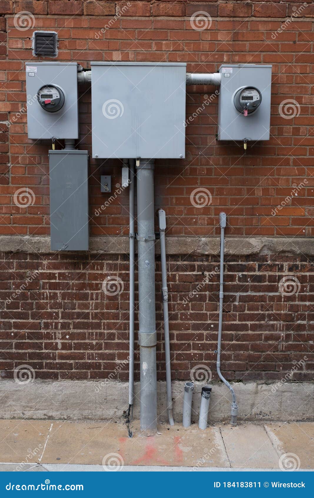 Vertical Closeup Shot of Electrical Wire Boxes on a Brick Wall Stock