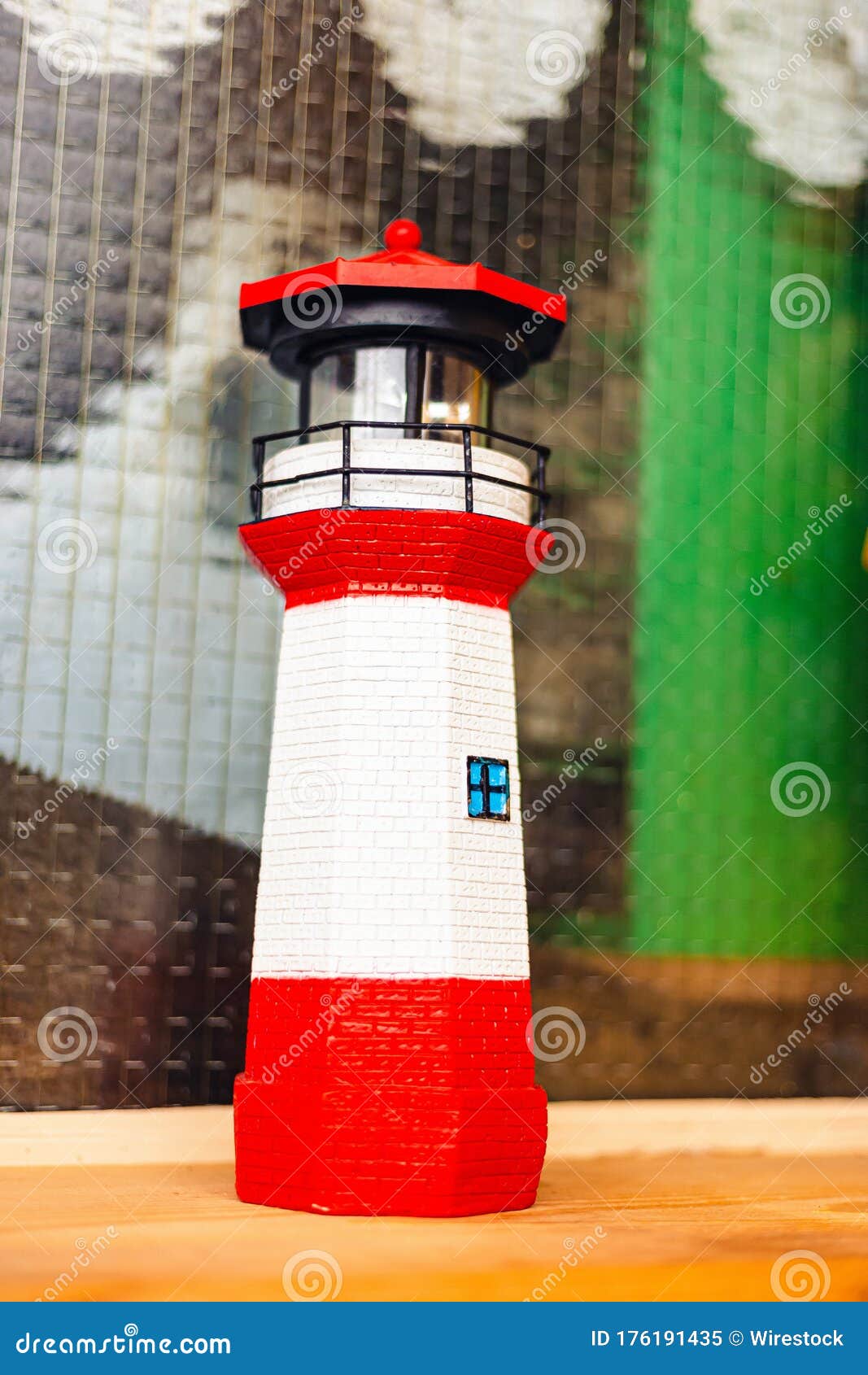 Vertical Closeup Shot of a Toy Lighthouse on a Wooden Surface Stock