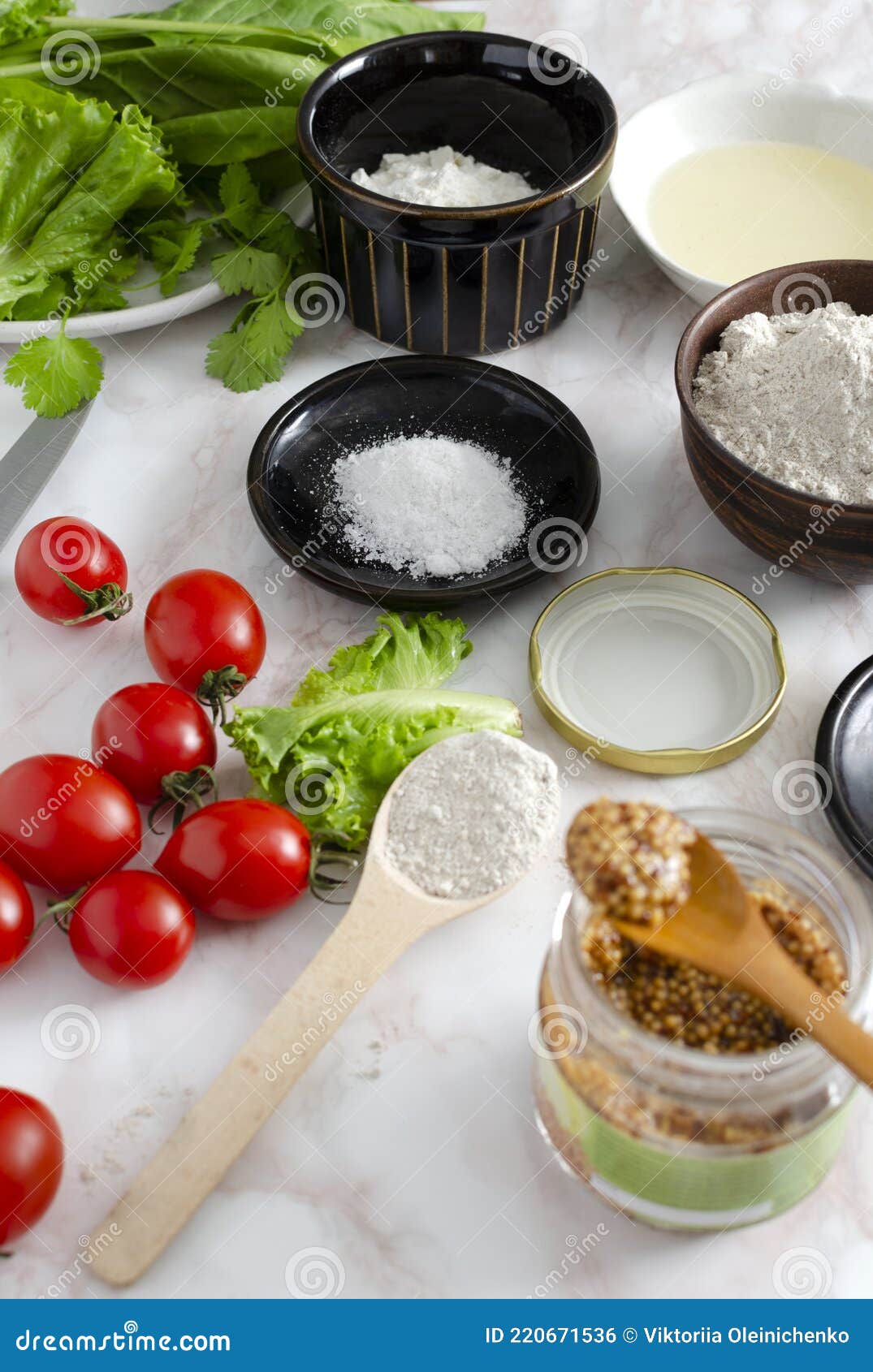vertical image of ingredients for vegan pizza.tomatoes,mustard,rye flour,lettuce and spinach, bowl of oil on the table