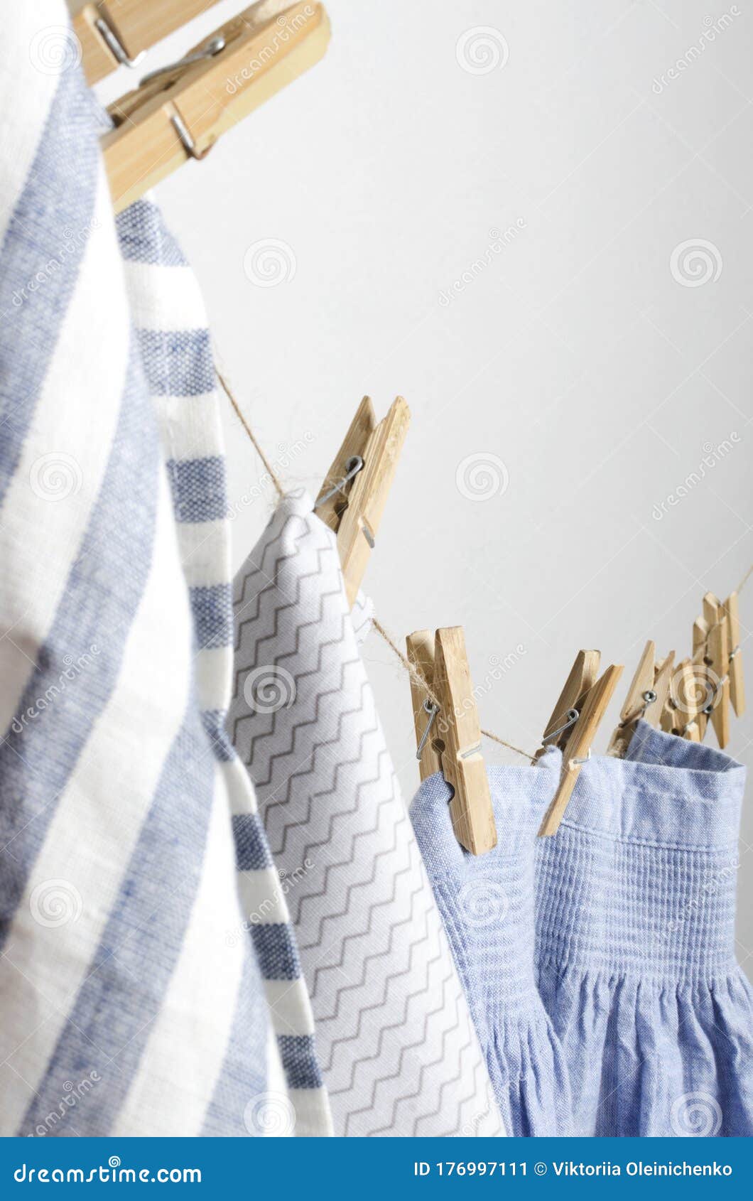 https://thumbs.dreamstime.com/z/vertical-image-laundry-drying-rope-hanging-wooden-pegs-different-kinds-clothes-rustic-blue-ad-white-fabrics-176997111.jpg