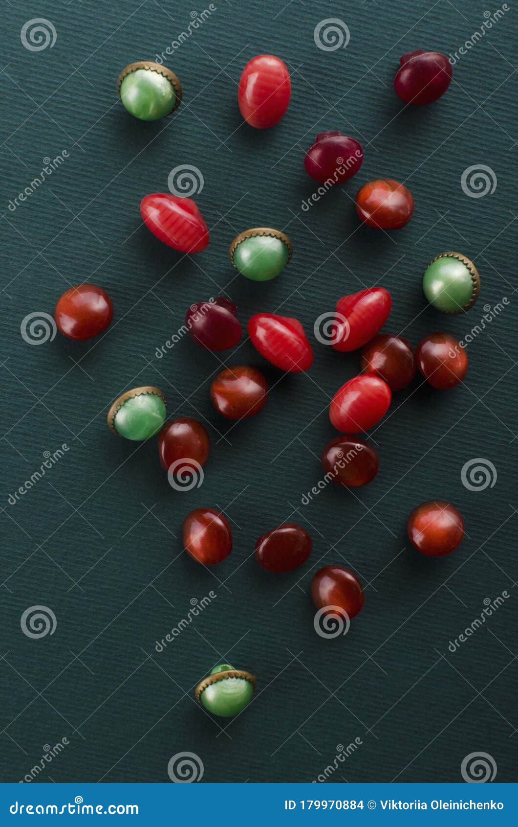 vertical image.red and green buttons for luxury clothing on the dark green surface