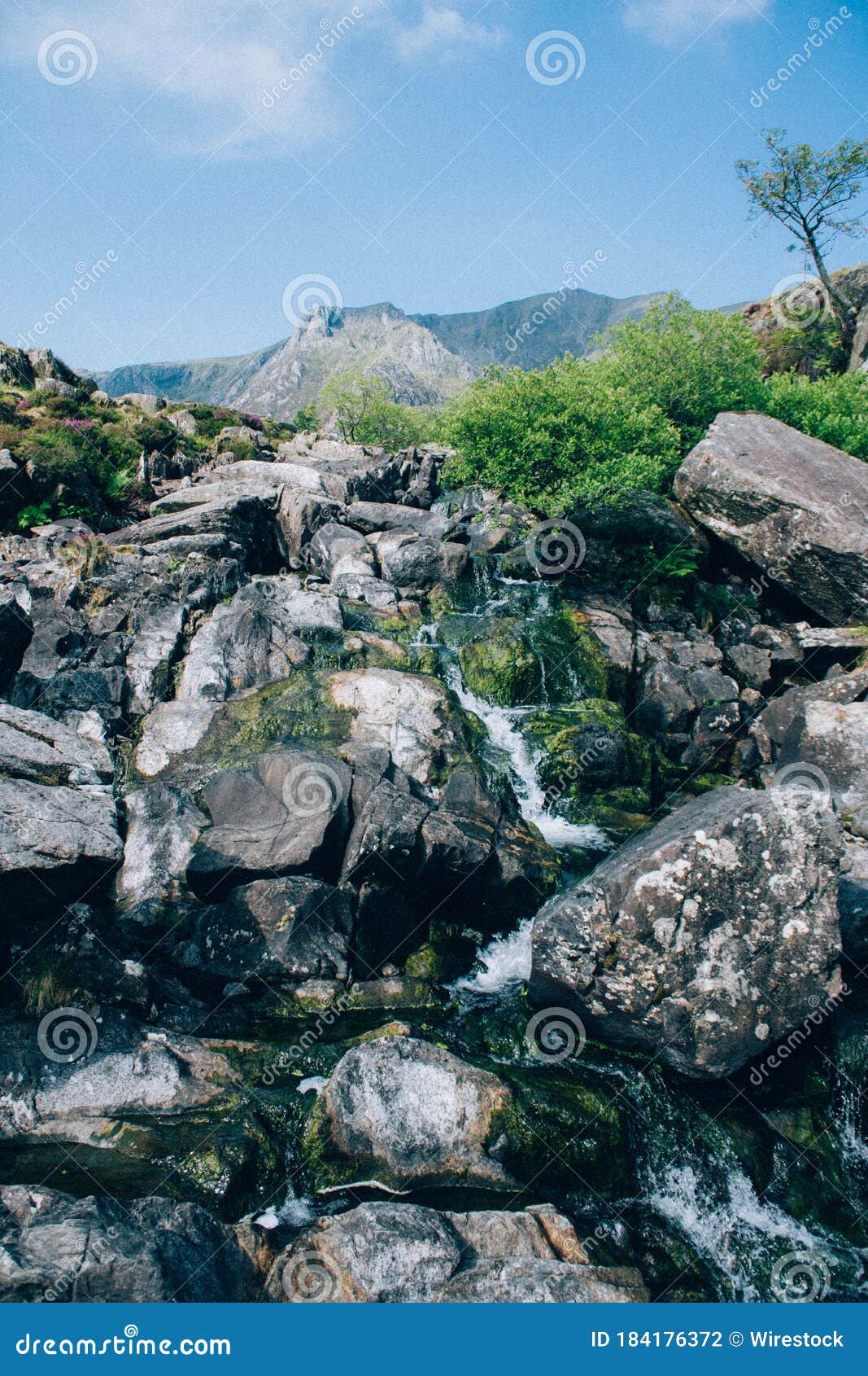 Vertical Low Angle Shot Of A Breathtaking Rocky Waterfall With Greens And High Mountain Stock Photo Image Of Nature Calm