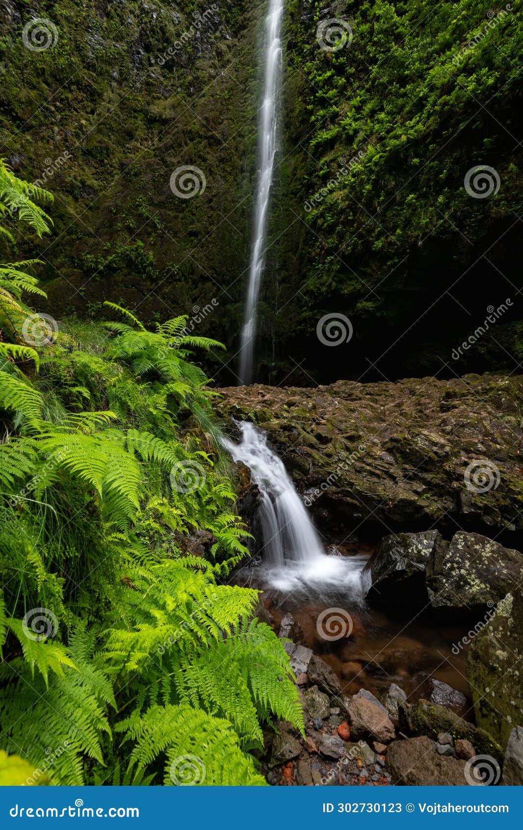 vertical photograph of a small cascade under the main waterfall of caldeirao verde valley.