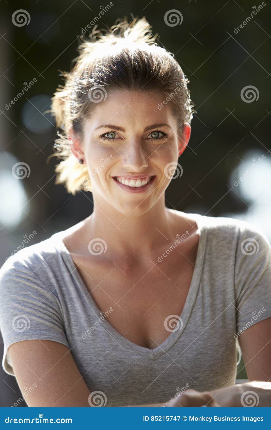 Vertical Portrait of Young White Woman Sitting Outdoors Stock Image