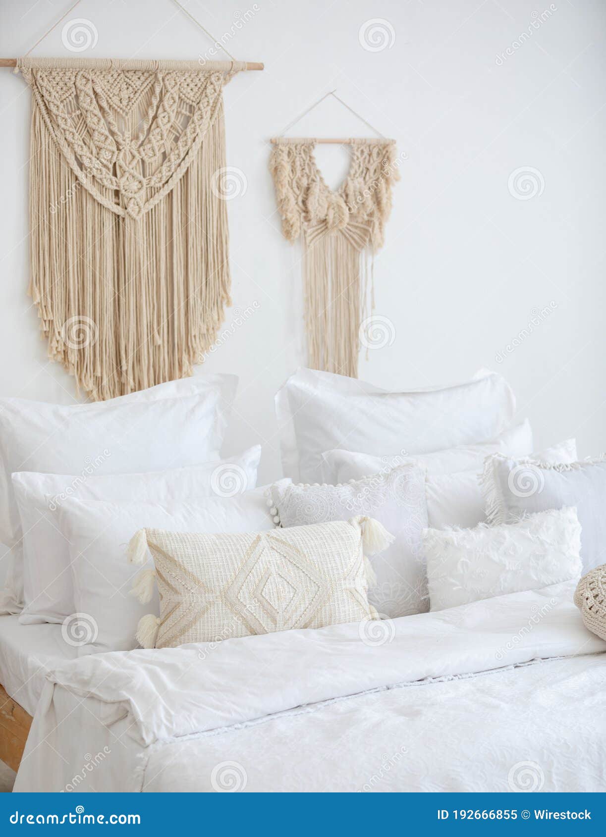 Vertical Shot of a Bed on Background of a Wall Decorated with Macrame