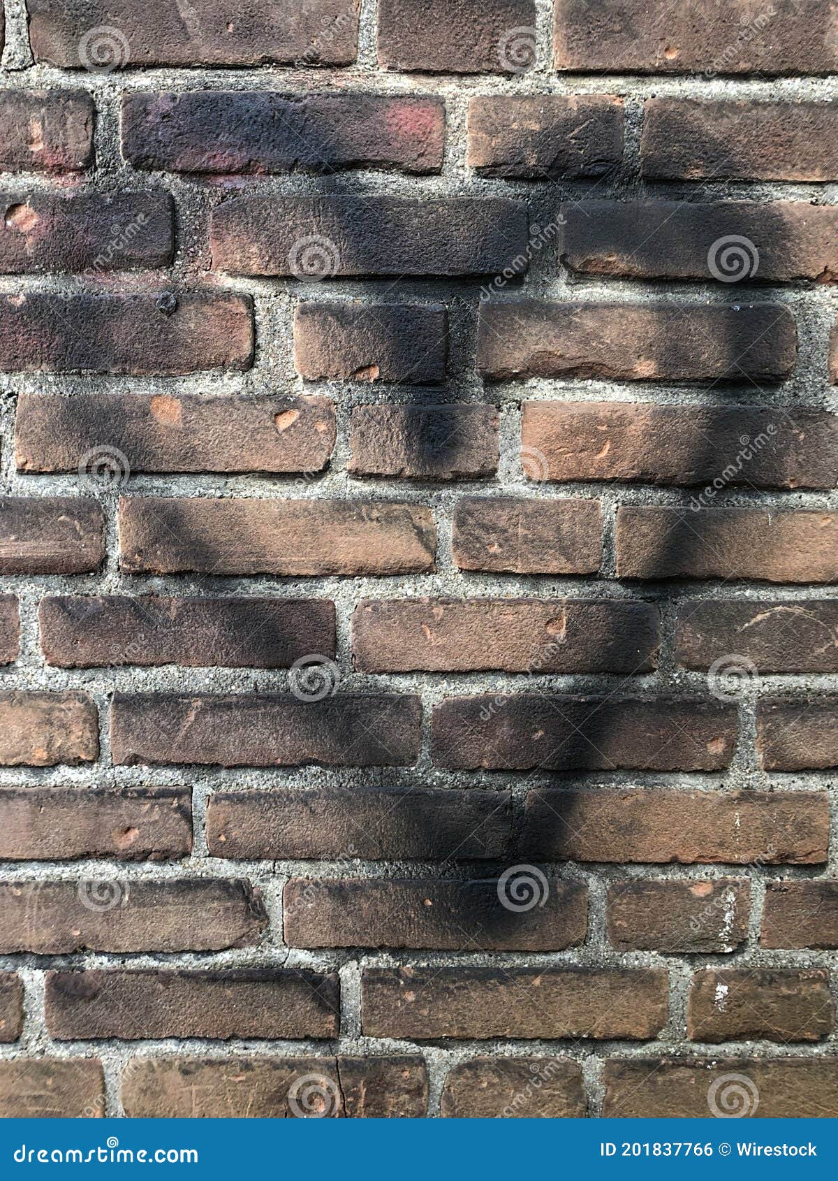 Vertical Shot of a Black Heart Graffiti on a Brick Wall Stock Photo