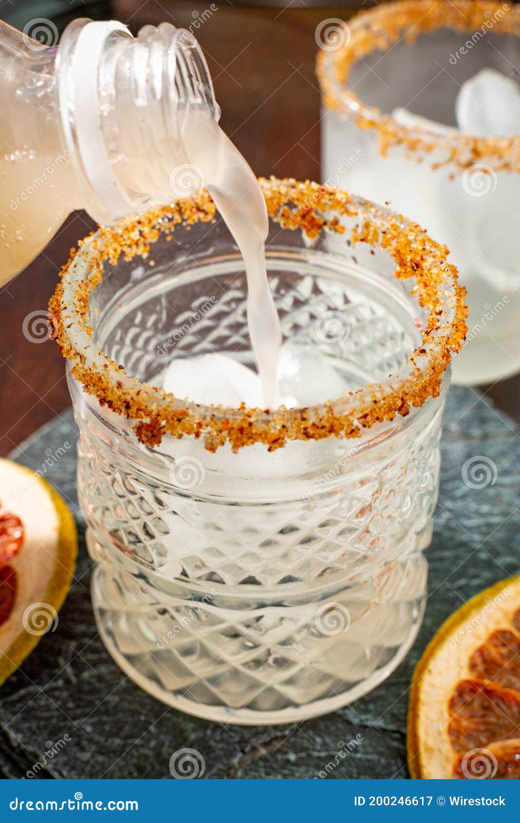Vertical Shot of a Bottle Pouring Juice into a Glass Stock Image