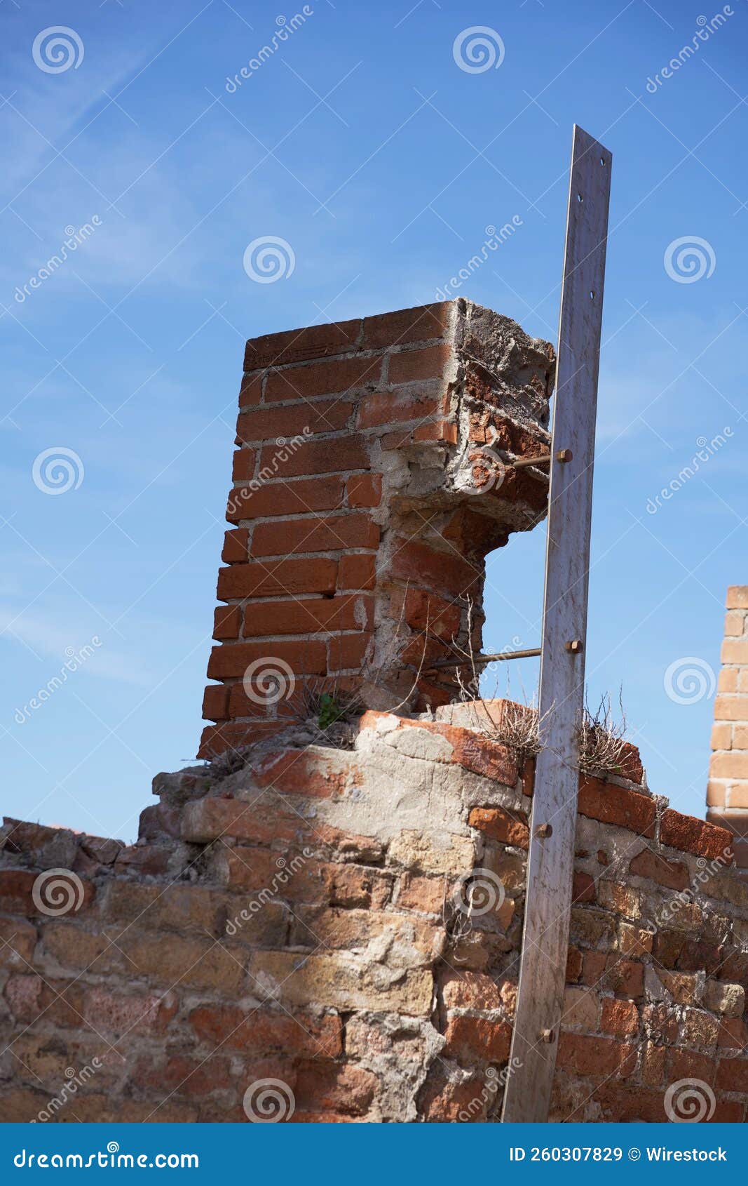 Vertical Shot of Brittle Brick Construction with a Blue Sky Background