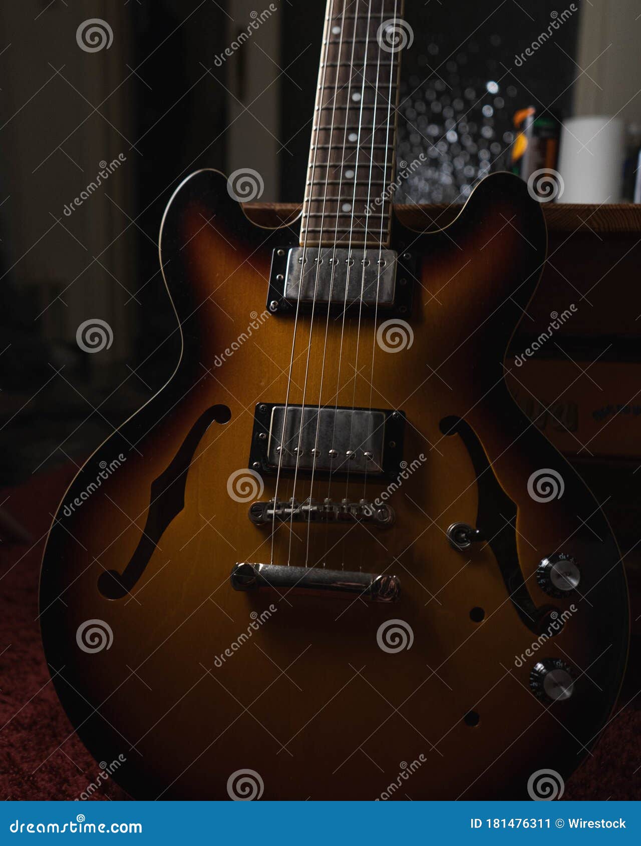Vertical Shot of a Brown Acoustic Guitar on the Ground Stock Image