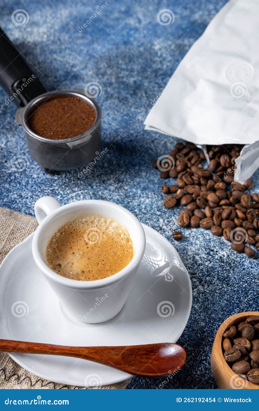 Vertical Shot of a Cup of Coffee, a Coffee Container and a Pile of