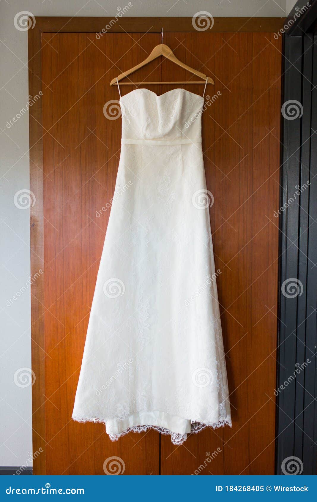 Vertical Shot of a Long White Dress Hanging from a Cloth Hanger on a ...