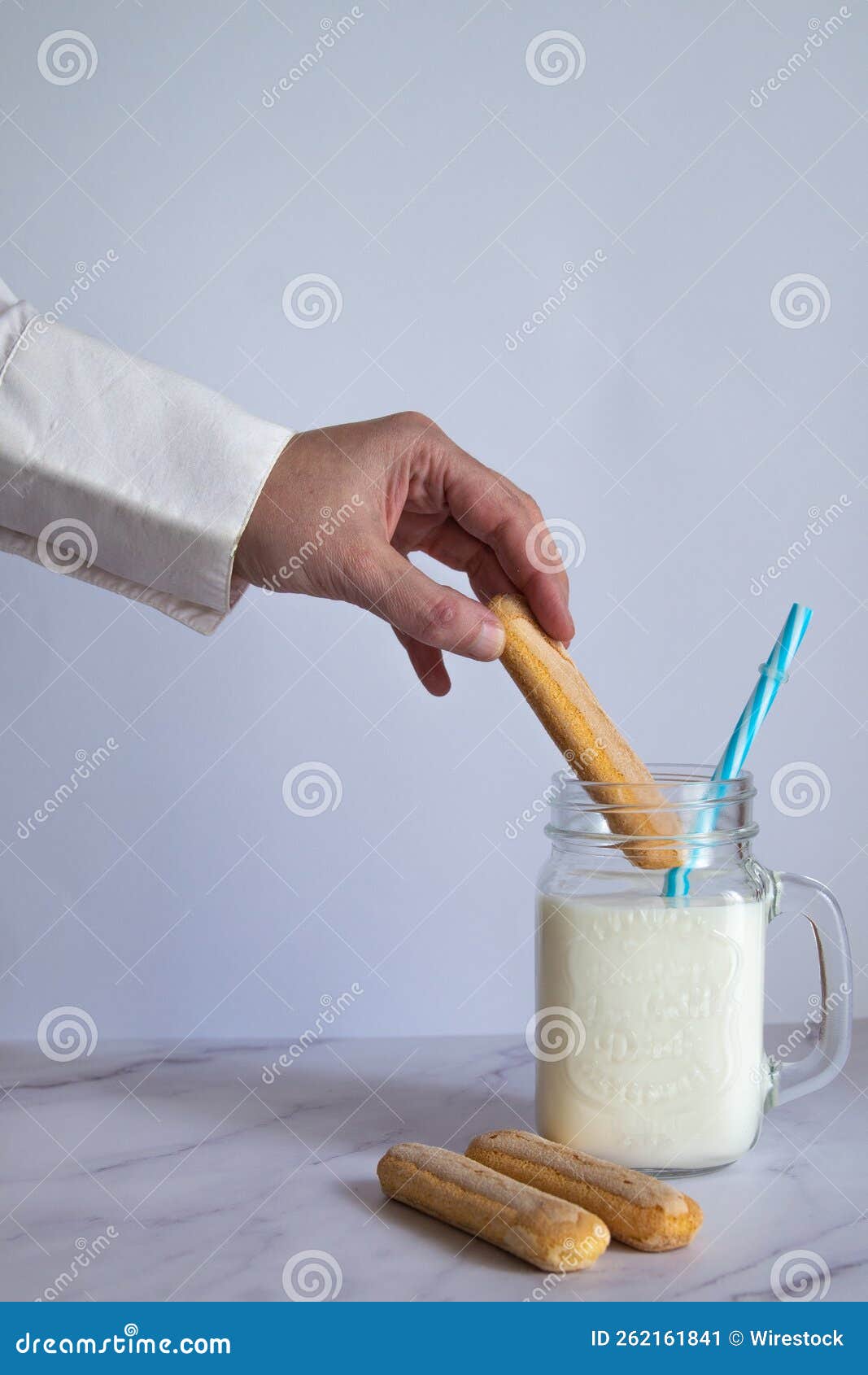 Vertical Shot of Male Hand Dipping Cookie on a Milkshake Stock Image