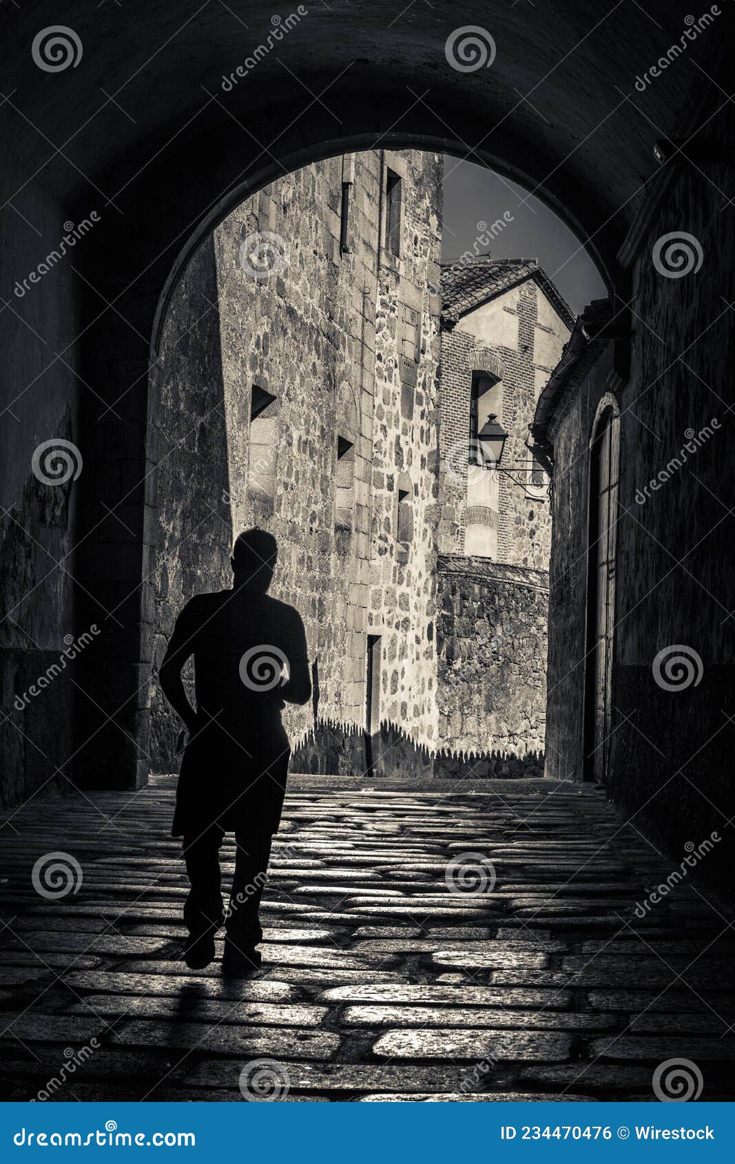 vertical shot of a man on the street in casco antiguo, caceres, extremadura, spain