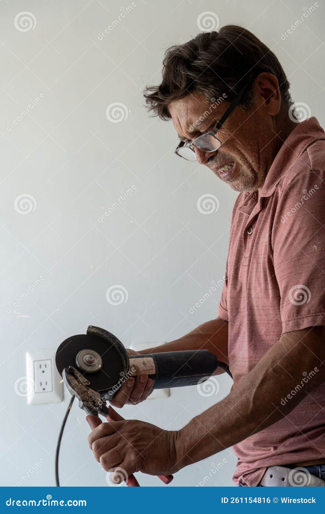 Vertical Shot of a Man Using Angle Grinder, Cutting a Screw, Friction