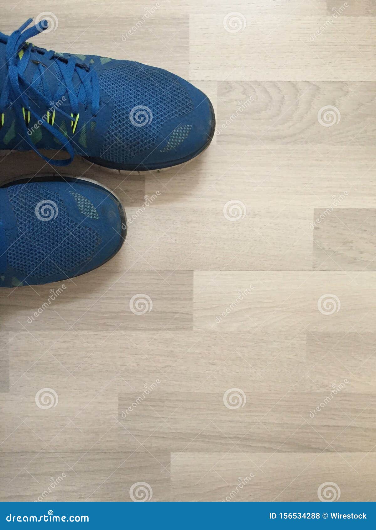 Vertical Shot of a Pair of Blue Running Shoes on a Wooden Surface Stock ...