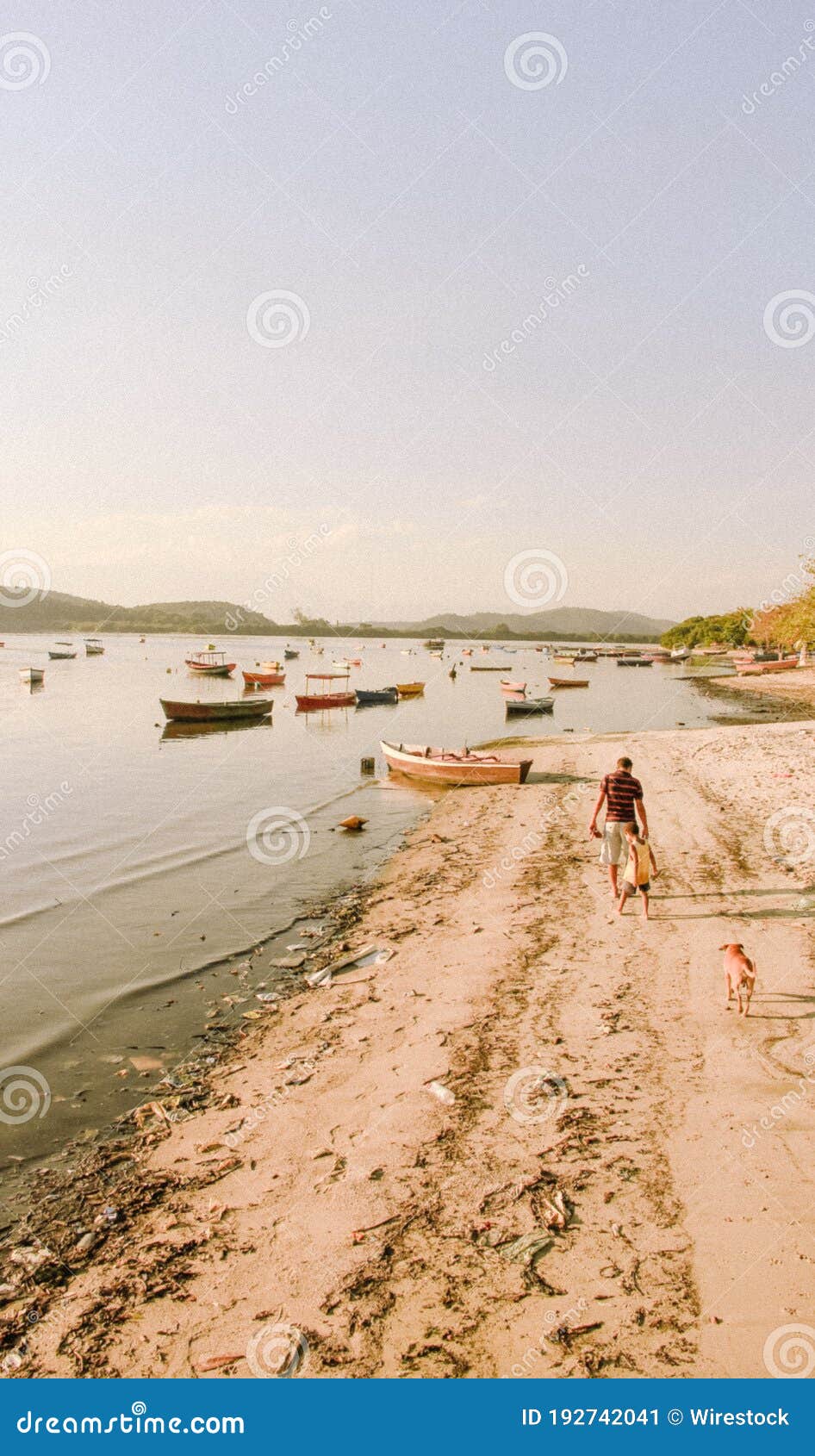 Vertical Shot of a People Walking Along a Beautiful Sandy Shore with  Fishing Boats on the Background Stock Image - Image of tranquil, sunny:  192742041