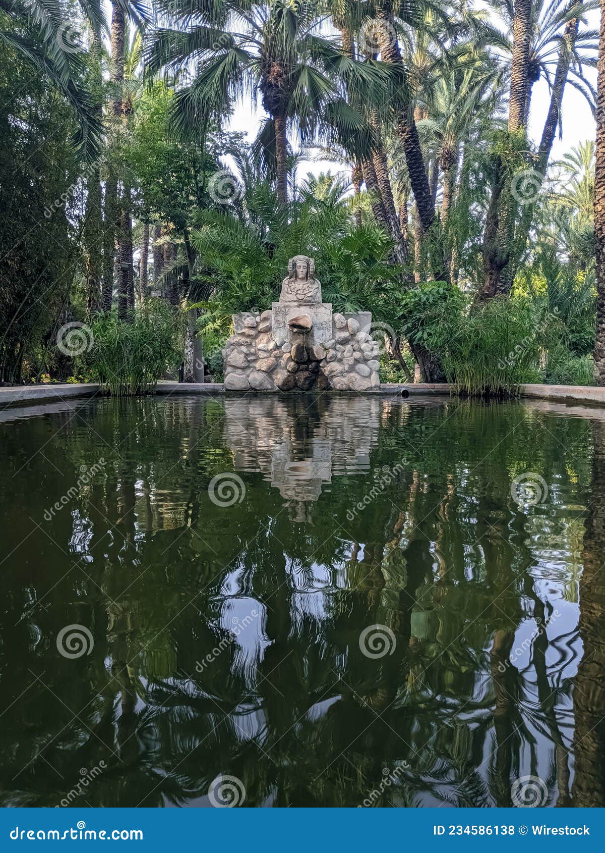 vertical shot of a pond at the huerto del cura national garden in spain