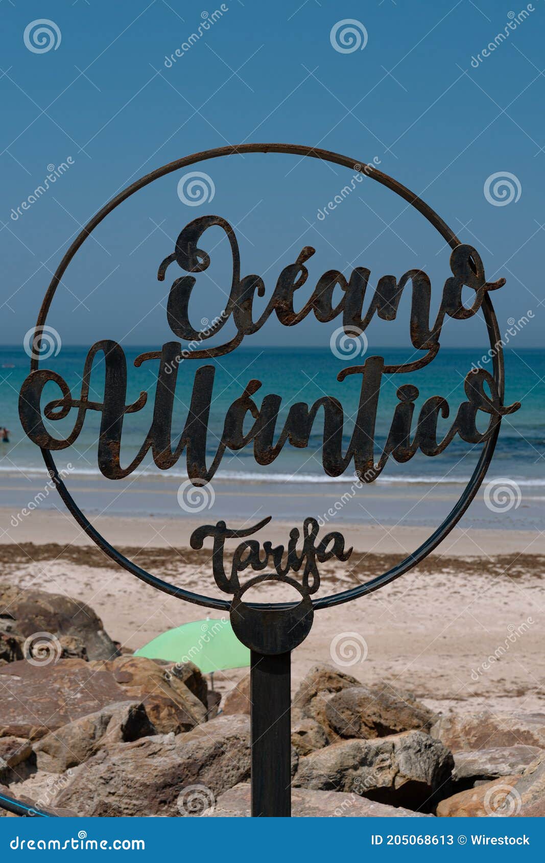 vertical shot of a oceano atlantico tarifa - atlantic ocean tarifa sign on the beach in spain