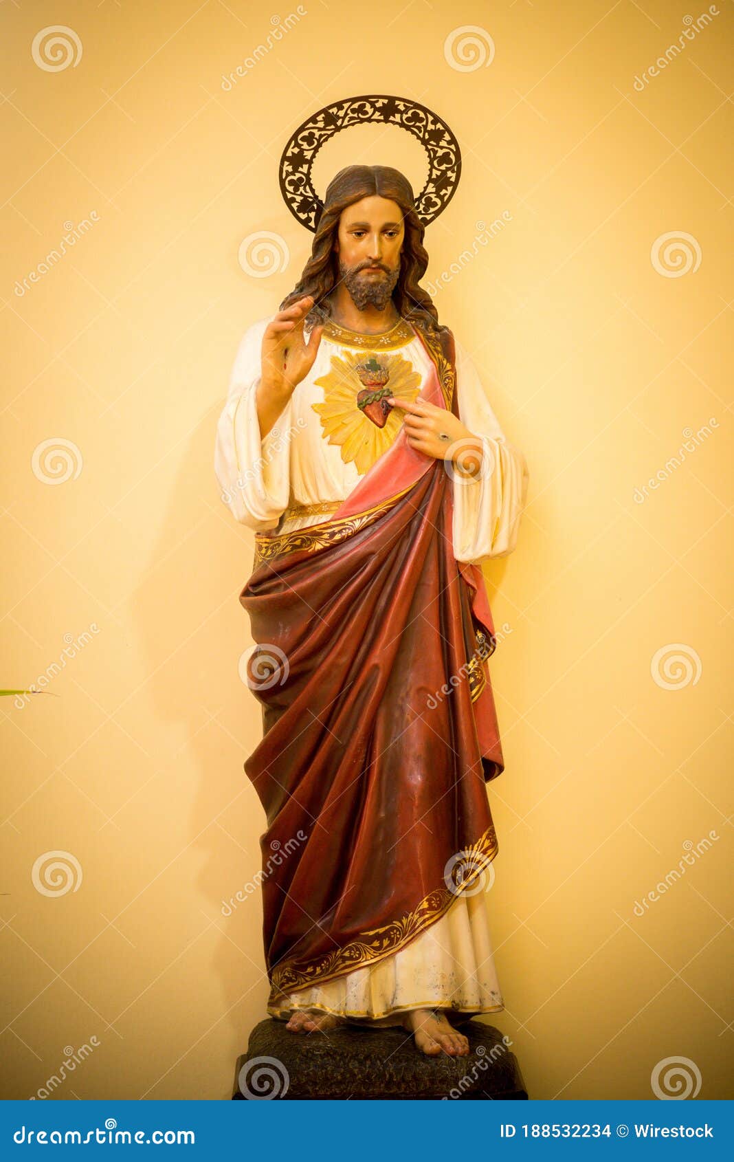 Vertical Shot of a Statue of Jesus Christ in a Red Robe on a Yellow ...