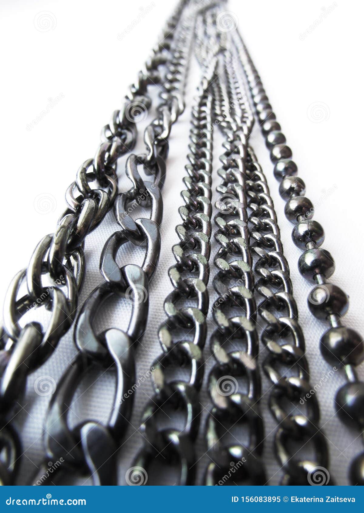 a vertical strip of shiny metal chains of various thicknesses extending into perspective on a white background