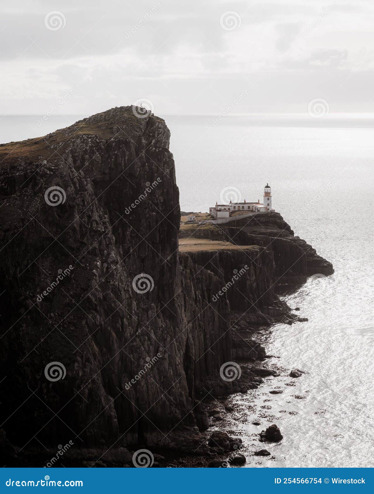 Vertical View of a Lighthouse on the Edge of the Cliff by the Sea Under ...