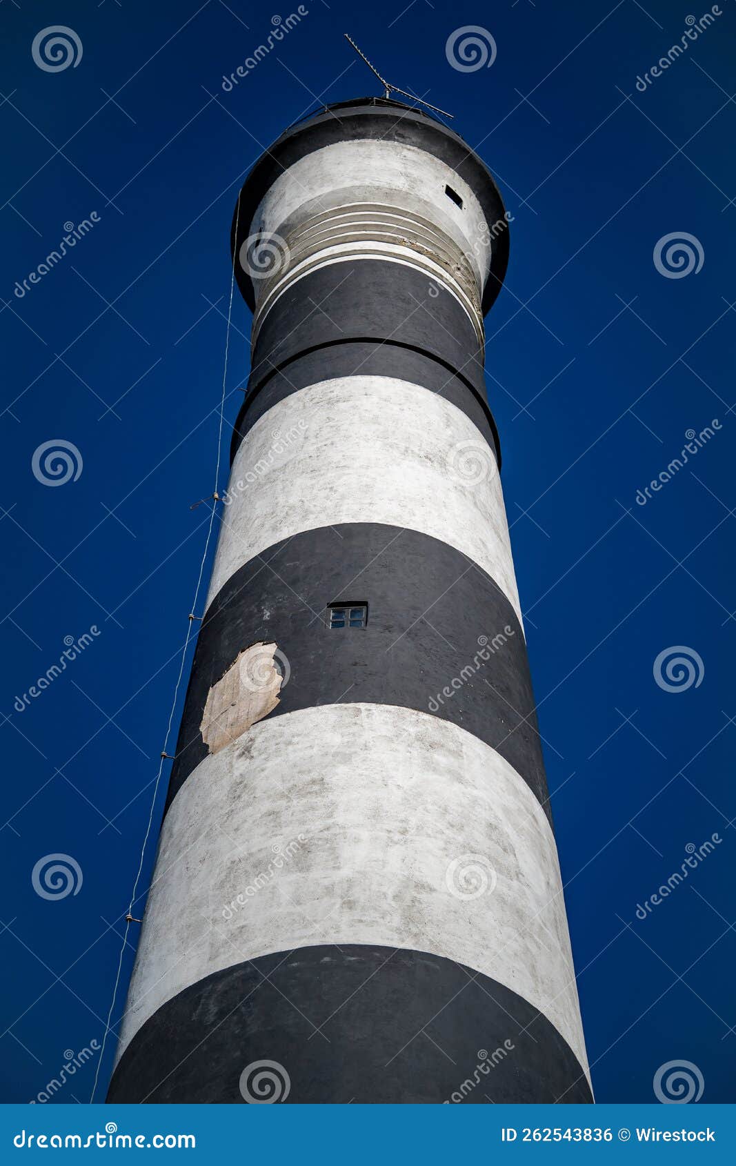 vertical view of a striped lighthouse in villa gesell partido, argentina