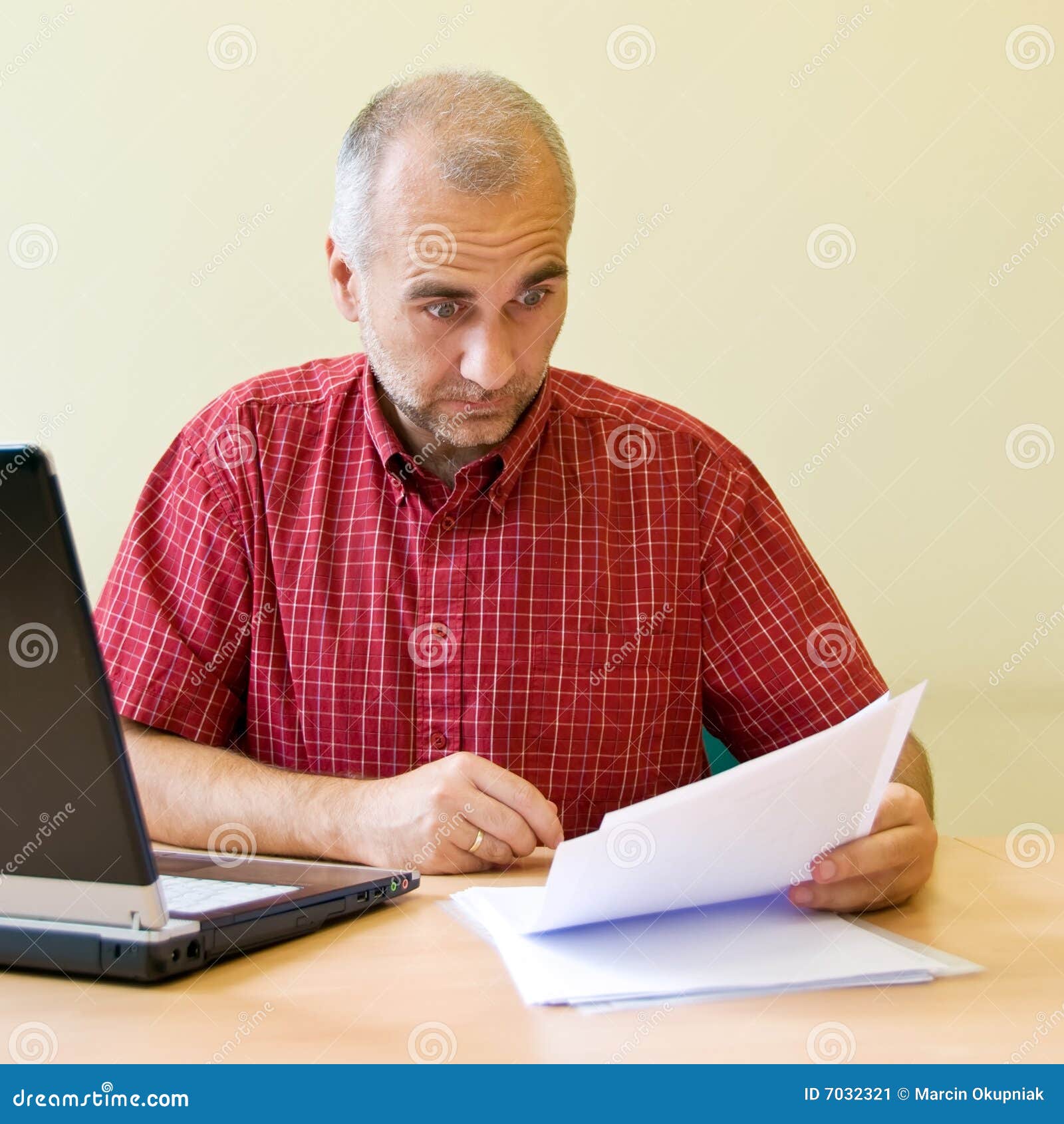 Verwarring. Verwarde beambte die overeenkomst bestudeert bij het bureau met laptop