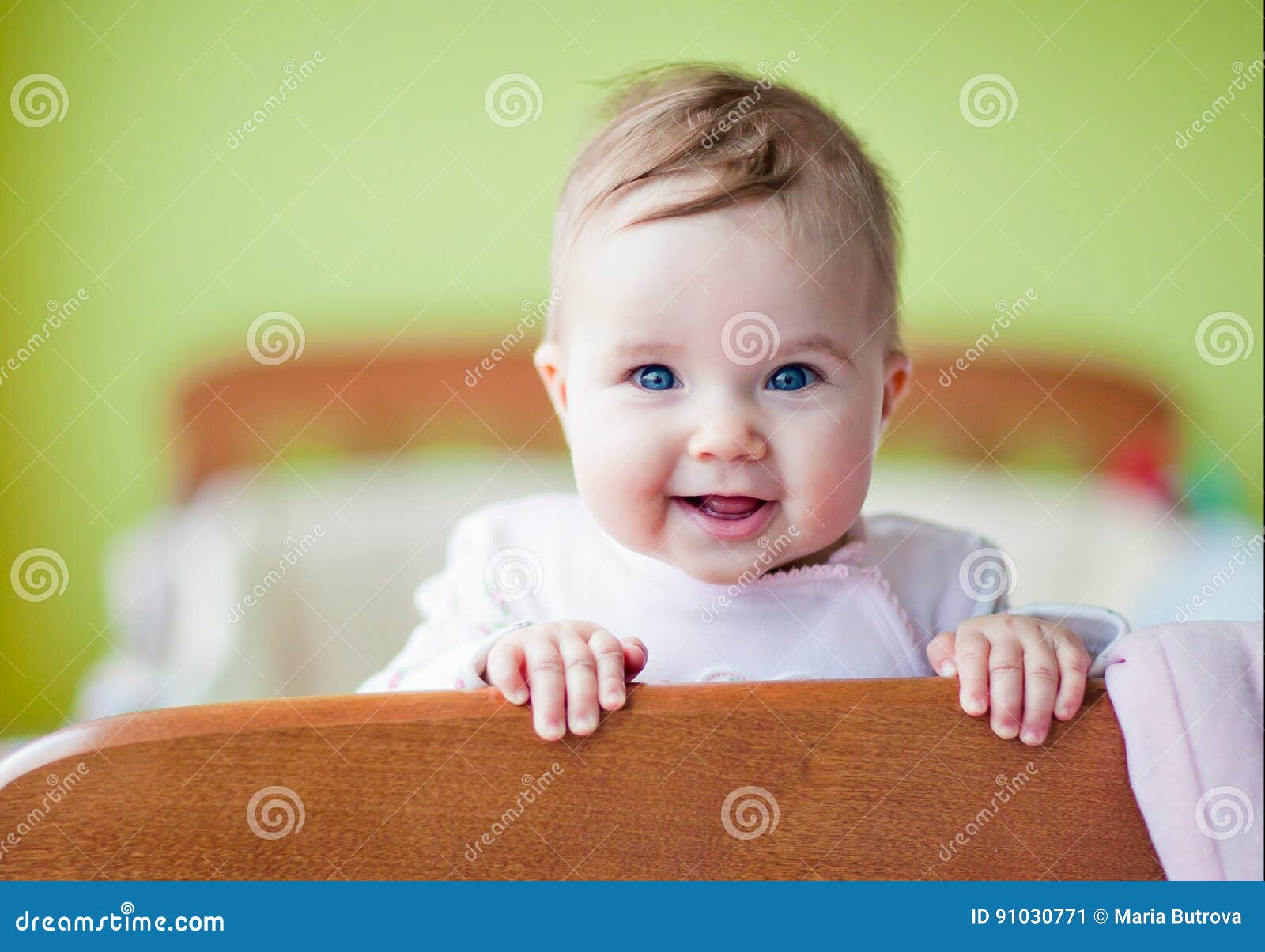 Very Cute Baby Smiles Standing In The Crib Stock Image - Image of