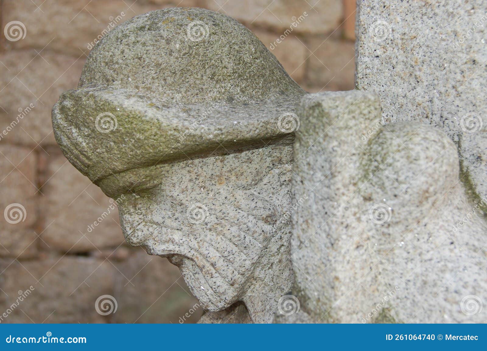very old pilgrim figure head sculpted on a column of a building in tui in portugal.