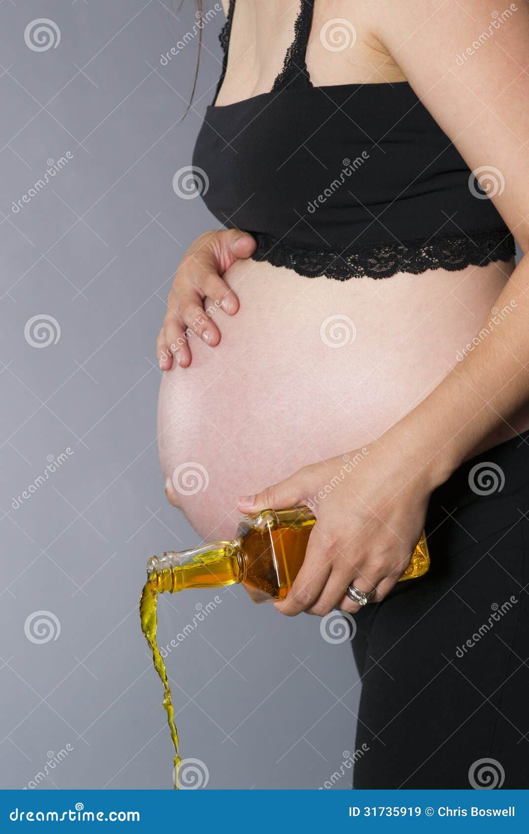 Very Pregnant Woman Pours Out Bottle Of Hard Liquor Whiskey Stock Image